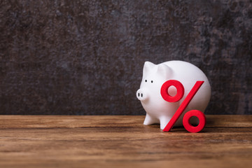 White Piggybank Over Cubic Block With Percentage Symbol
