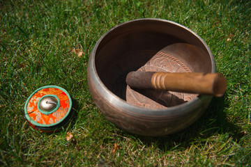 tibetan singing bowl on green grass in park