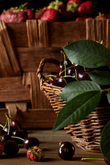 close-up shot of cherries and strawberries in basket and box
