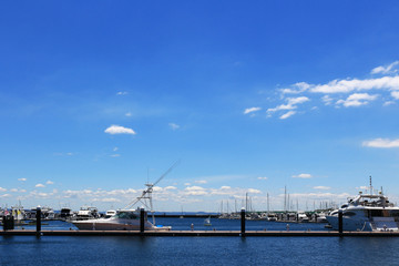 Fototapeta na wymiar Luxurious summer view of the marina with a stylish cruiser moored