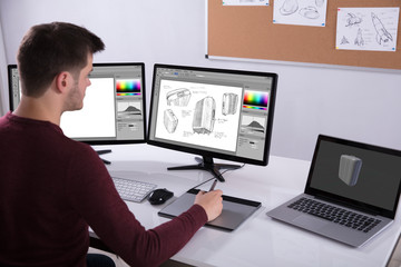 Designer Drawing Suitcase On Computer Using Graphic Tablet