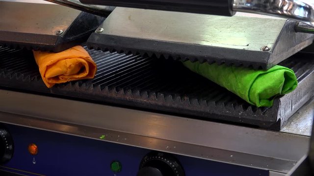 Roasting the color pita shawarma in an electric grill.