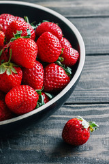 Strawberries in a bowl on a wooden table