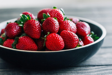 Strawberries in a bowl on a wooden table