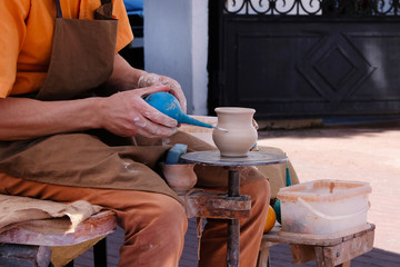 Artist makes clay pottery on a circle. Pottery and craftsmanship concept.