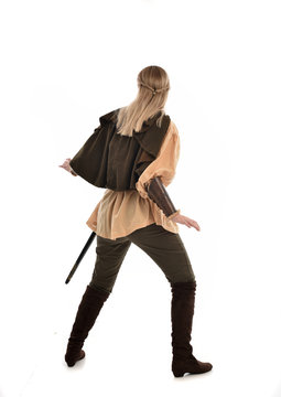 Full Length Portrait Of Girl Wearing Medieval Costume With Sword. Standing Pose With Back To The Camera, Isolated On White Studio Background.