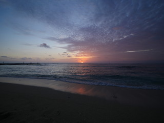 sun setting into the ocean horizon Hawaii