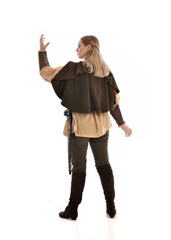 full length portrait of girl wearing medieval costume with sword. standing pose with back to the camera, isolated on white studio background.