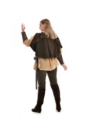 Fototapeta premium full length portrait of girl wearing medieval costume with sword. standing pose with back to the camera, isolated on white studio background.