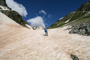 Tourist walking on snow in the Caucasus mountains