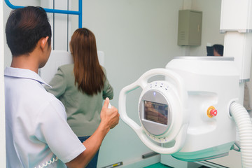 Asian male radiologist preparing and setting up X-rays.