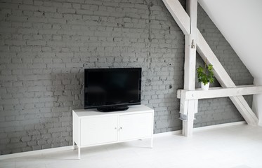 Modern flat lcd television set on white cabinet.