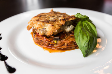 European international fusion cuisine, a beautiful dish on a white plate decorated with herbs and vegetables. a professional chef has prepared a delicious meal.