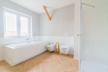 Bathtub and glass shower cabin in loft bathroom.