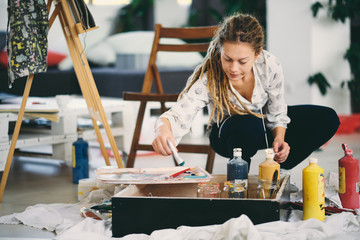 Fototapeta premium Artistic girl mixing colors for painting.