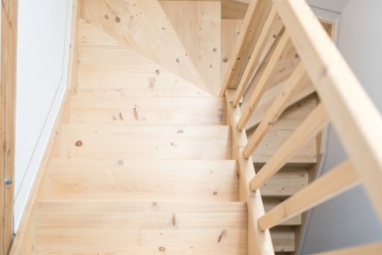Wooden pine stairs in hall.