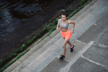 overhead view of young female jogger running in city