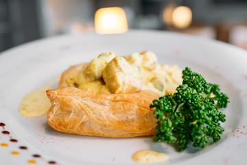 European international fusion cuisine, a beautiful dish on a white plate decorated with herbs and vegetables. a professional chef has prepared a delicious meal.