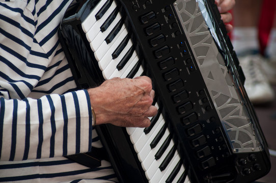 closeup of hands of man playing accordion in the street
