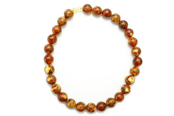 Amber. Beads made from natural yellow brown amber mineral on a white background. Fashionable jewelry amber beads from round and oblong beads. Sun stone as a jeweler raw material. Frozen Resin Fossil