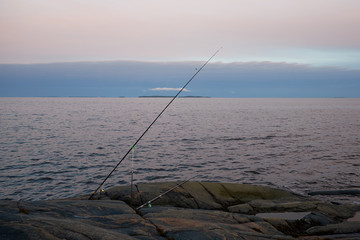 the fishing pole is on a rocky shore