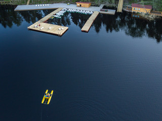 Aerial view of a man who swims on a lake on a pedal catamaran, a water bike