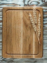 Chopping board rye ears on vintage wooden surface