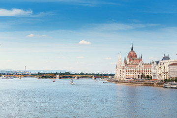 Obraz premium a classic view of the famous tourist attraction of Budapest - the Hungarian Parliament and the Danube River with ships