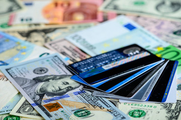 Dollar vs euro banknotes and credit cards as background. Concept
