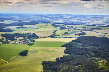 Aerial view of South Bohemian landscape with fields, forests and dramatic sky in Czech Republic.