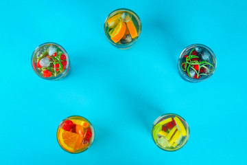 Various detox water in glasses, different tastes, berries, fruits.