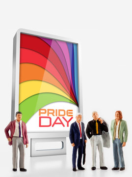miniature people - A group of men standing in front a board about the Gay Pride