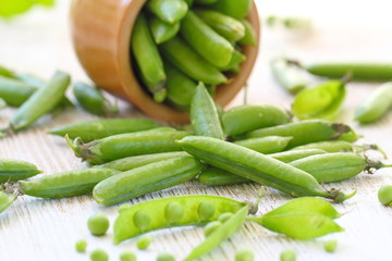 Fresh green peas in ceramic bowl.