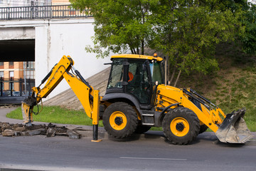 Working on the excavator pulls out of the ground old curbstone