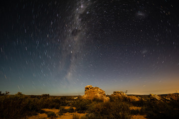 Star trails in the Kagga Kamma Nature Reserve with rock formations in the foreground