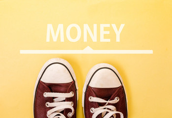 sneakers standing next to line and word MONEY
