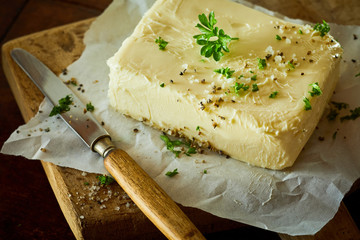 Block of fresh butter with herbs and knife