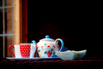 A pot of tea, with a dotty mug and sugar bowl, ready for tea in the sun.
