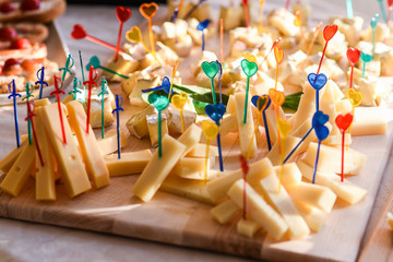 Many pieces og cheese on spears on the buffet table