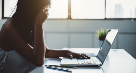 Fototapeta premium Young asian business woman feeling hurt, fatigue, headache, and stressed working with laptop in office, office syndrome concept