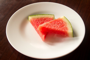Slice of delicious watermelon on white plate background