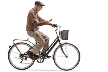 Naklejka premium Senior riding a bike and looking at his phone