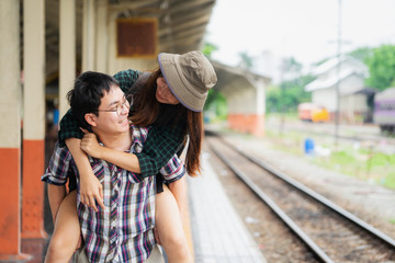 Young man giving girlfriend piggyback ride