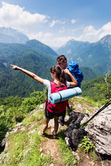 Obraz premium Couple backpackers enjoying mountains view