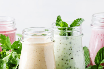 Healthy and useful colorful berry smoothies with yogurt, fresh fruit and berries on a gray background, selective focus