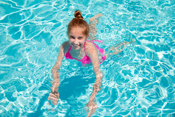 Fototapeta na wymiar Teenage girl swimming in swimming pool