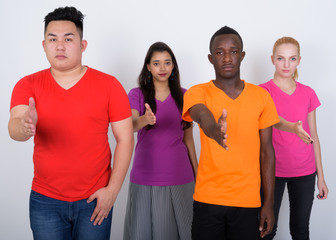Studio shot of diverse group of multi ethnic friends giving hand