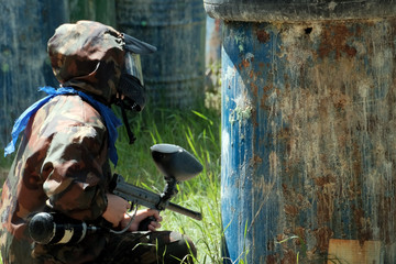 Mask, weapons, camouflage and a blue handkerchief from the player during the game of paintball....