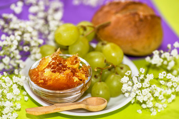 Honey in honeycomb, grapes and bread.