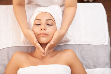 Fototapeta na wymiar View of young relaxed female having facial massage for skin rejuvenation